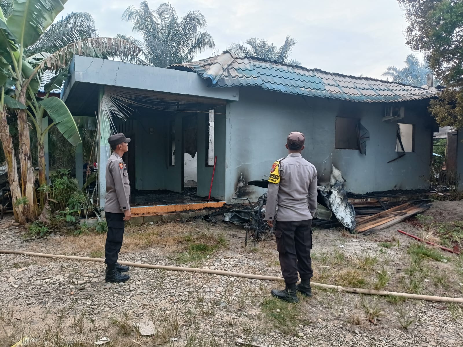 Polisi dari Polsubsektor Simangambat saat mengecek lokasi kebakaran Rumah permanen yang ditinggal pemilik keluar kota